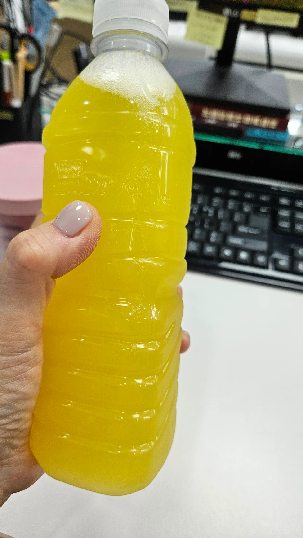 루텔스 비타민C 음료가 담긴 물병을 들고 있는 손의 다른 각도